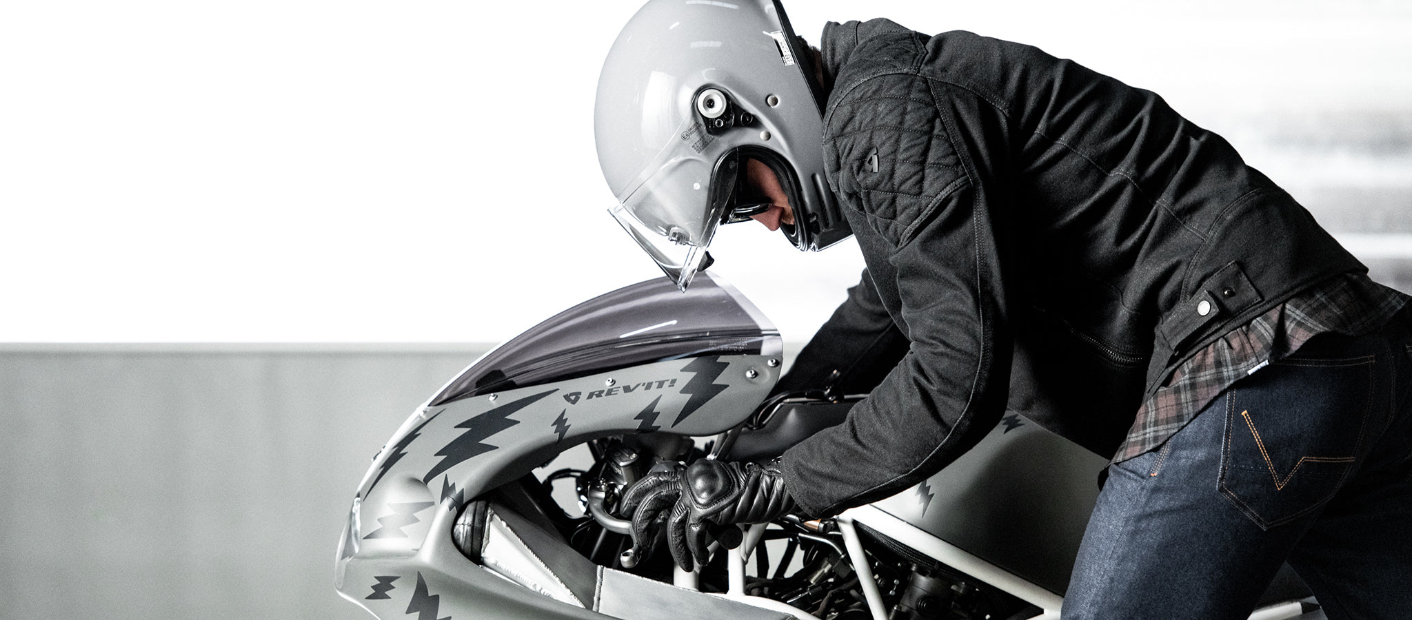Male motorcyclist hopping on his bike, wearing REV'IT! motorcycle gear