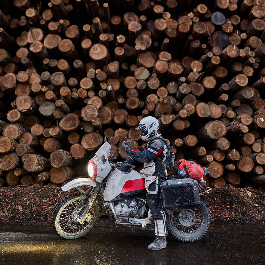 Adventure motorcyclist sits astride his bike, wearing REV'IT! Defender 3 GTX apparel.