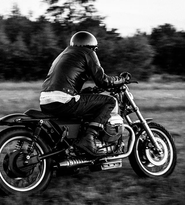 Black and white lifestyle image of a motorcyclist wearing REV'IT! motorcycle apparel, riding his motorbike