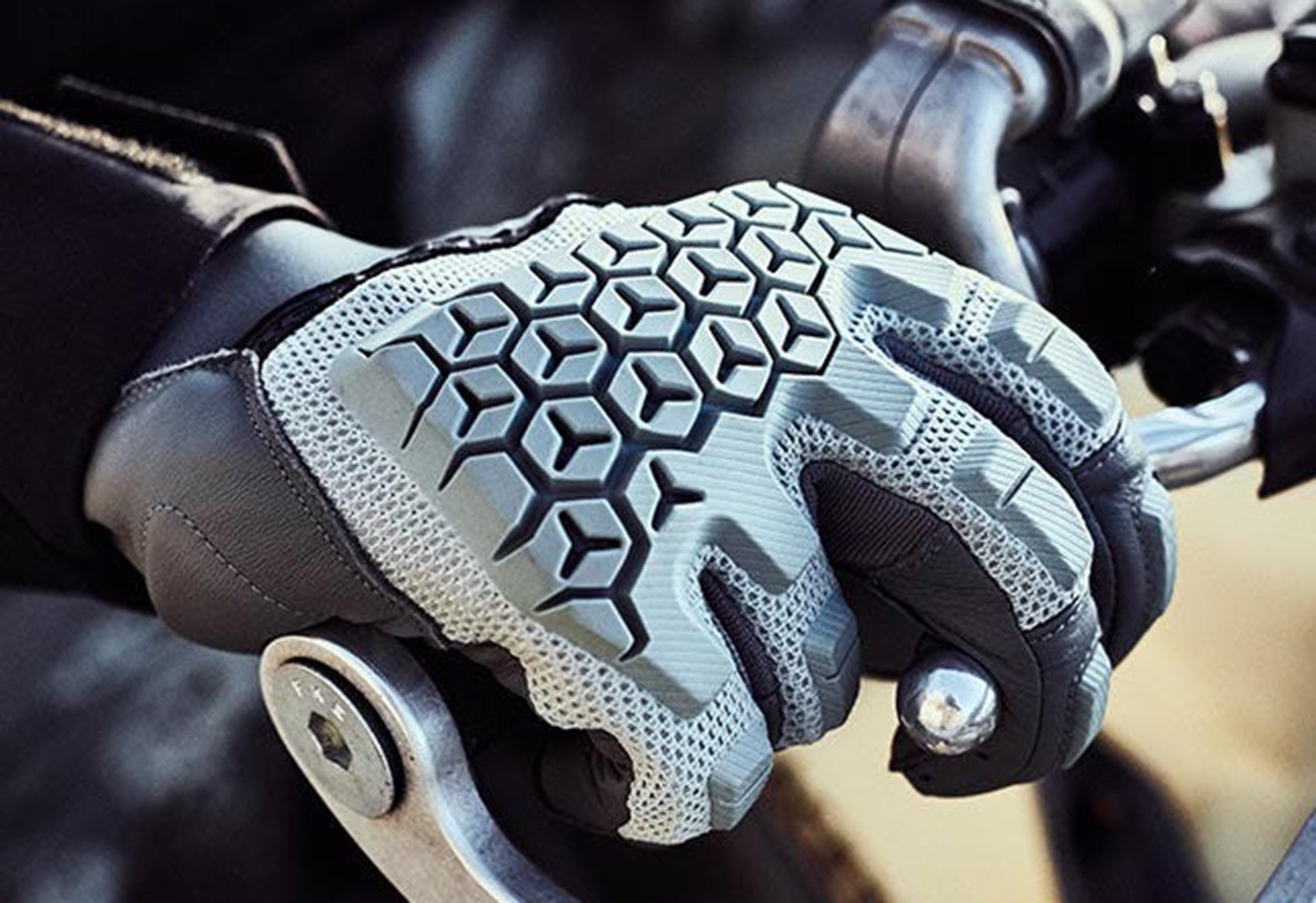 Close-up image of a motorcyclist pulling the front brake lever while wearing a pair of REV'IT! dirt gloves