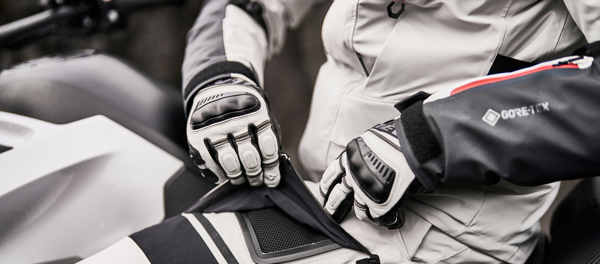 Close-up image of a motorcyclist opening the air vent on a pair of REV'IT! motorcycle pants