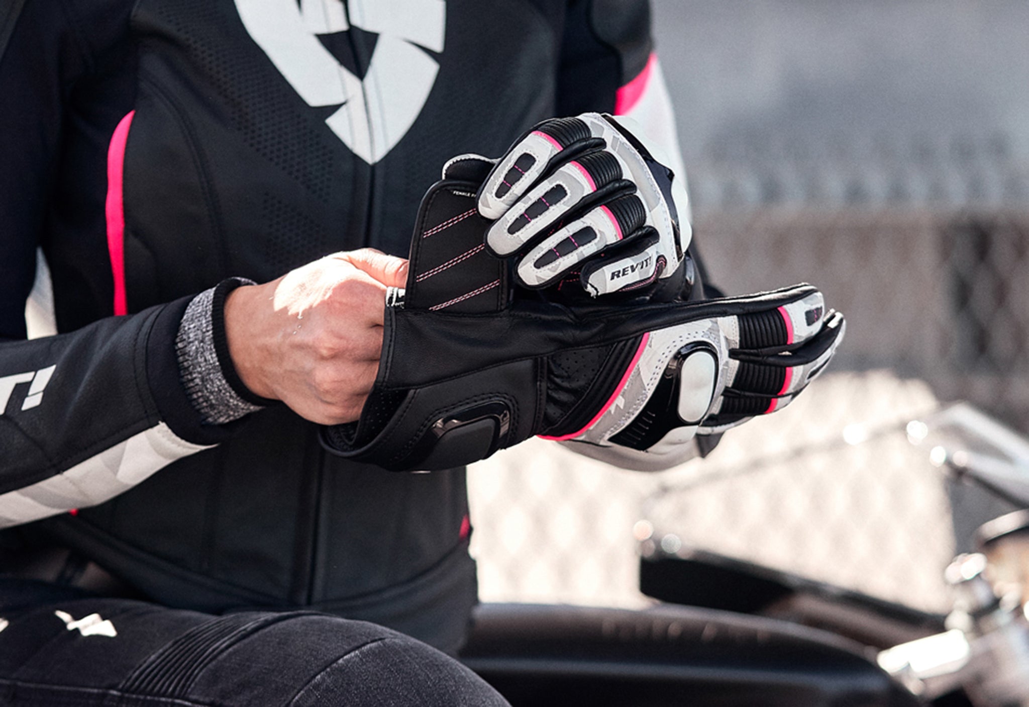 Close-up image of a female motorcyclist pulling on a pair of REV'IT! motorcycle gloves